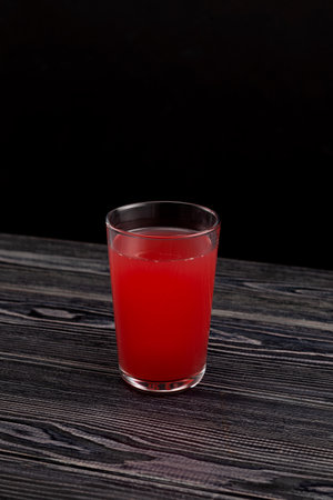 Glass of Red fruit Tepache drink. Fermented beverage made from peel and rind of pineapples. Tepache sweetened either with piloncillo or brown sugar and served cold.の写真素材