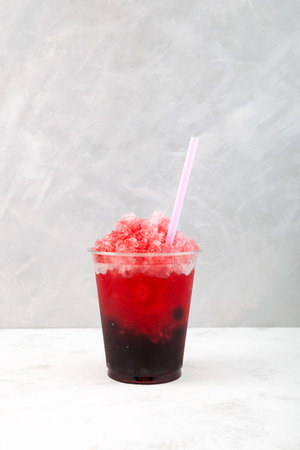 Sweet watermelon shaved ice with tapioca pearls in disposable take away plastic cup. Red Fruit berries cocktail, Bubble tea. Refreshing summer drink. street food.の写真素材