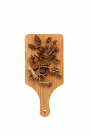 Dried fruits and seeds of Sophora japonica on white background, close-up. Sophora japonica are used in alternative medicine, contain rutin, fatty oils, linoleic acid. Chinese Herbal Medicine.の写真素材
