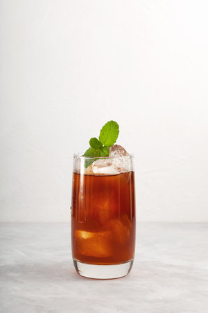 Iced Tamarind drink or Tamarind ice tea in tall glass. Refreshing summer mexican drink with natural ingredients. Agua de Tamarindo.の写真素材