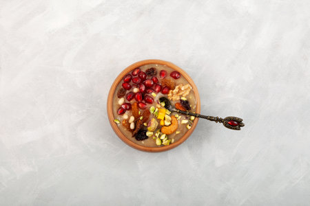 Ashure Dessert, Ashura or Anusabur on gray background, top view. Turkish delicious porridge with grains, fruits, and nuts. Sweet pudding also called as Noah's pudding or Noah's Dessert.の写真素材