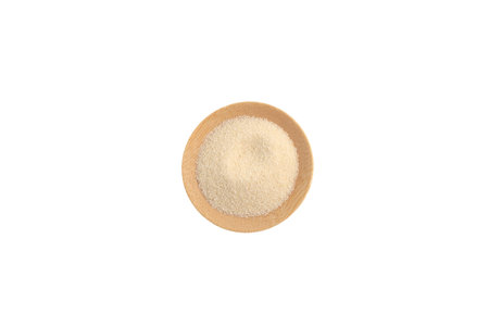 Wheat Semolina in wooden plate on white background, top view. Design element, copy space.の写真素材