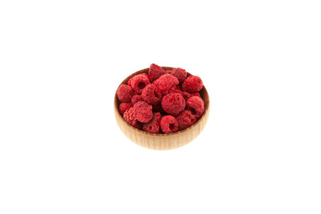 Dried freeze dried raspberries in wooden bowl on white background. Selective focus, copy space. Dehydrated raspberries. Clever Storage healthy food.の写真素材