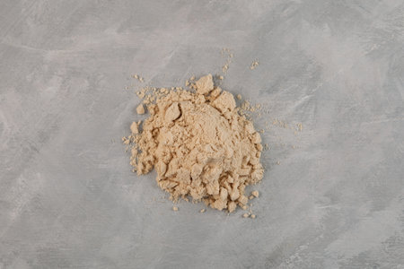 Pile of Soy Protein isolate on gray textured background, top view. superfood. Pure powder isolated from soybean is often used to increase the efficiency of fat burning.の写真素材