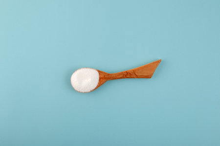 Succinic acid powder in wooden spoon. Butanedioic acid or spirit of amber. It is marketed as food additive E363, used as an acidity regulator in the food and beverage industry.の写真素材