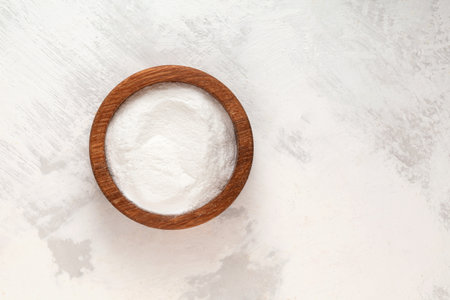 Succinic acid powder in wooden bowl, top view. Butanedioic acid or spirit of amber. Chemical formula C4H6O4. Food additive E363, white powder, used as acidity regulator in food.の写真素材