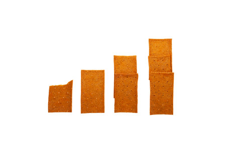 Crispy rye bread. Crisps with paprika on white background in the form columns of growing graph. Increased demand and consumption of dry food with long shelf life. Wholegrain crispbread.の写真素材