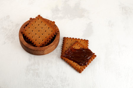 Cookies or crackers with Vegemite spread. Vegemite is a very popular thick Australian healthy food spread made from leftover brewers yeast extract. Selective focus, copy space.の写真素材