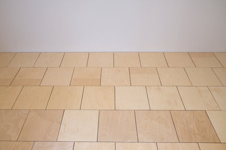 apartment renovation. light wall. Floor covered with plywood sheets. Preparation of base for laying finishing floor covering, parquet or laminate. Selective focus, copy space.の写真素材
