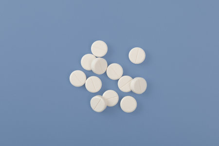 White pills or tablets on blue background. Concept Placebo effect in medicine. Tendency increased consumption of medications, antidepressants and sedative pills.の写真素材