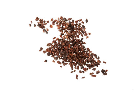 Cocoa nibs scattered on white background. Design element. Crunchy pieces of peeled, crushed and lightly roasted cocoa beans with pleasant chocolate bitterness. Sugar-free product.の写真素材
