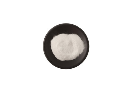 Succinic acid in dark plate on white background, top view. Butanedioic acid or spirit of amber. Food additive E363, white powder, acidity regulator, acidifier. Chemical formula C4H6O4.の写真素材
