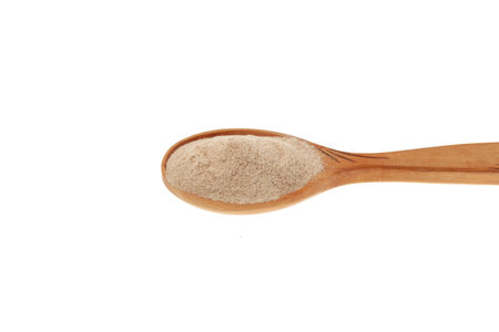 Psyllium (Ispaghula) Husk in wooden spoon, close-up. Psyllium coarse flour. Dietary Fiber Food Supplement. White background, copy space, design element.の写真素材
