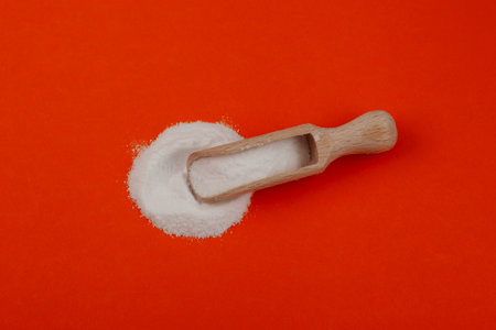 Succinic acid powder in wooden scoop, top view. Butanedioic acid or spirit of amber. Food additive...
