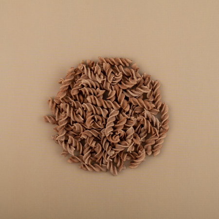 Pasta di Lino or Flaxseed gluten free pasta on beige background, top view. Low glycemic index food. Fusilli made from flax and corn flour.の写真素材