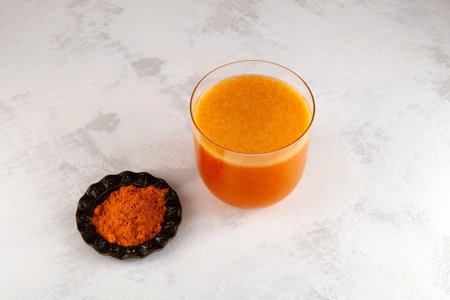 Buckthorn and mango fruits energy drink with natural turmeric powder on the table, top view. Healthy smoothie for immune support. Antioxidant drink.の写真素材