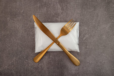 White powder with chemical formula NaNO2. Sodium nitrite or preservative E250 in plastic bag. Golden fork and knife symbolize the prohibition or refusal to use dangerous food additives with E number.の写真素材