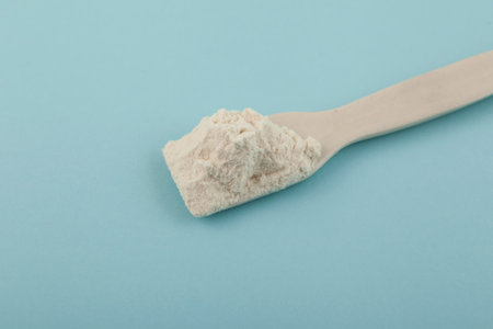 Ceramic spatula with Guar gum powder, close-up. Food additive E412 widely used in bakery, confectionery products. Softness, Fat Replacer, Dough Improver, Improve Moisture, Structure, Texture.の写真素材