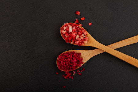 Freeze dried strawberries and raspberries in wooden spoons, close-up. Dehydrated strawberry berries. Delicious fruits topping for porridge, cereal, yogurt and desserts.の写真素材