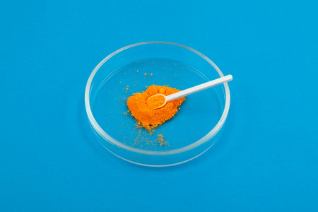 Tartrazine powder in Petri dish with measuring spoon. Synthetic lemon yellow azo dye. Food additive E102. Tartrazine, usually labeled as CI 19140 or FD&C Yellow 5.の写真素材