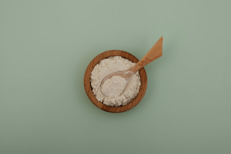 Guar gum powder or guaran in wooden bowl with spoon, top view. Food additive E412, Thickening agent, Binder, Excessive Water absorber. Guar Gum used in cosmetics and food industry.の写真素材
