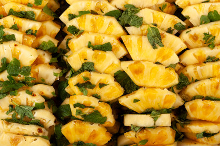 Pineapple slices with mint leaf in sugar syrup, close-up. Sliced sweet pineapple. Delicious fruit dessert.の写真素材