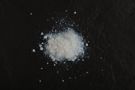 Pile of Colloidal silicon dioxide on black stone surface, top view.の写真素材
