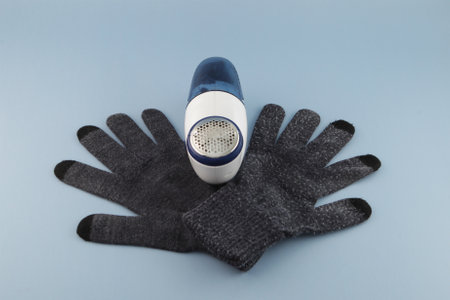Pilling portable machine and woolen knitted gloves with pellets. Clothes fabric shaver. Hair ball...