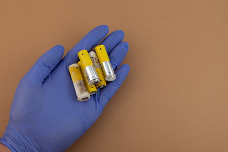 Old used alkaline batteries LR6 type or AA, close-up. Oxidized and leaked batteries, leakage of alkaline electrolyte. Concept of separate waste collection. Problems of electronic waste recycling.の写真素材