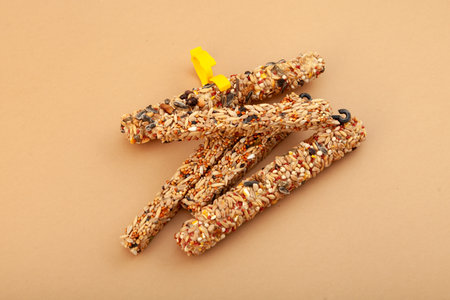 Two types pressed grain sticks for rodents and birds with a convenient plastic clip for mounting on cage and hook for hanging. Balanced dry food additive for domestic animals.の写真素材