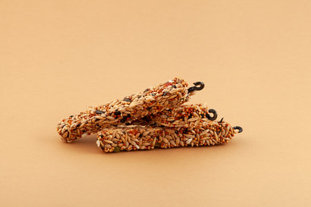 Pressed grain sticks for small rodents and birds with convenient hook for hanging. Delicious, healthy treat for hamsters, parrots and other pets.の写真素材