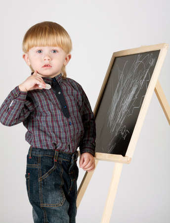 little boy draws on blackboardの写真素材