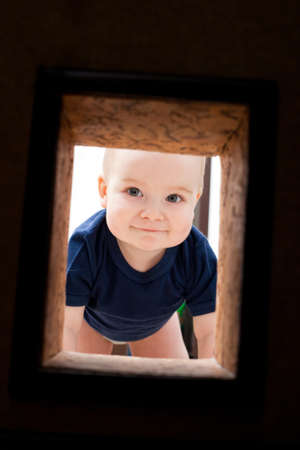 Little child looks to hole in the wallの写真素材