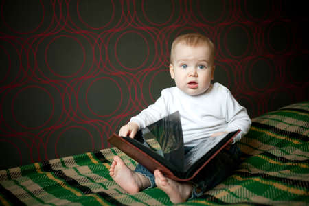 little boy reading book at home