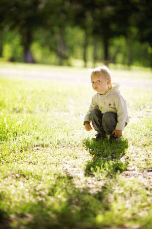 little funny boy sitting in grassの写真素材