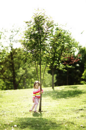 little happy girl near the treeの写真素材