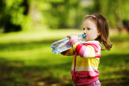 little girl drinks mineral waterの写真素材