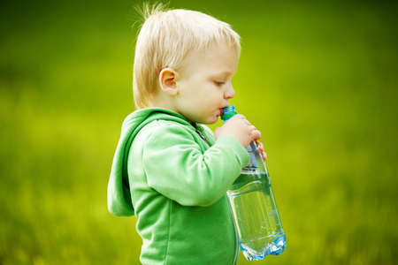 little boy drinks mineral waterの写真素材
