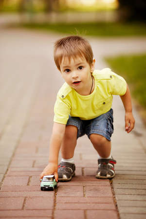 little boy plays with toy carの写真素材