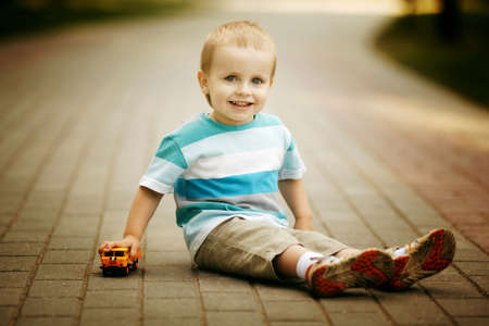 little boy plays with toy carの写真素材