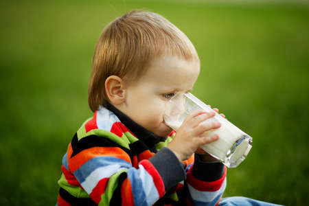 little boy with glass of milkの写真素材