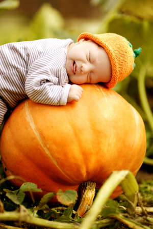 baby sleeping on big pumpkinの写真素材