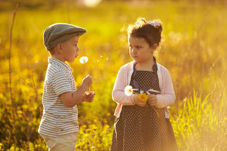 cute boy and girl on summer fieldの写真素材