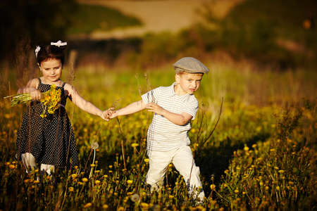 cute boy and girl on summer fieldの写真素材