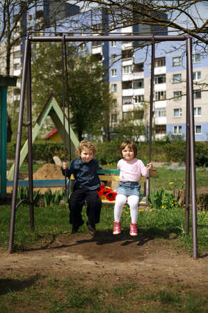 boy and girl on the swingsの写真素材