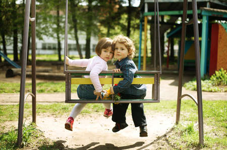 boy and girl on the swingsの写真素材
