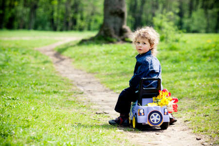 little boy on a toy-car in parkの写真素材