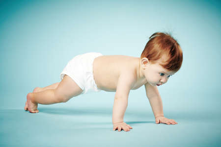 sweet child crawls on blue backgroundの写真素材