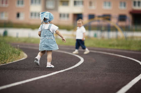 funny little children playing on stadiumの写真素材
