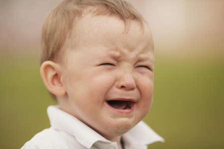 little crying boy close-up portraitの写真素材